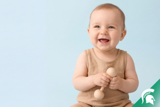 Baby Smiling with MSU helmet in bottom corner