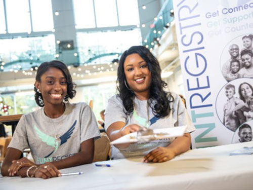 Two women handing out Flint Registry information sitting at a table