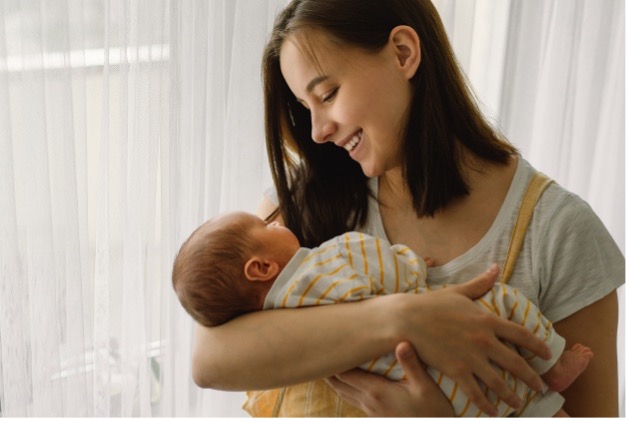 mother holding baby smiling