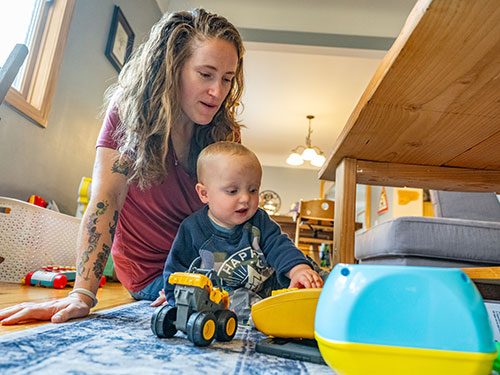 a woman playing with her baby on the floor