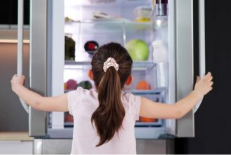 Young girl looking into fridge